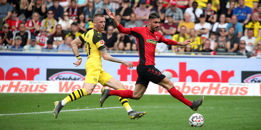 Vincenzo Grifo vom SC Freiburg setzt sich im Dribbling gegen Marius Wolf von Borussia Dortmund durch