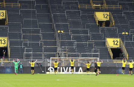 Die Spieler des BVB feiern ihren Derbysieg vor der leeren Südtribüne.
