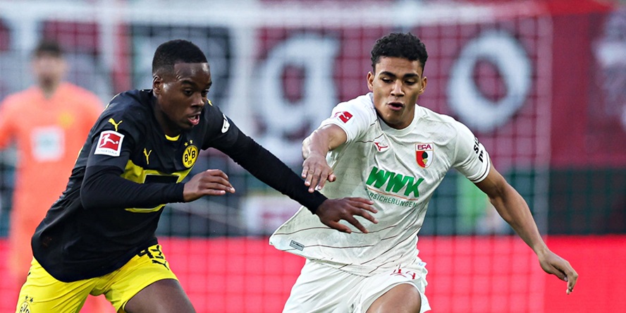 Henri Koudossou (FC Augsburg) im Duell mit Jamie Gittens (BVB)