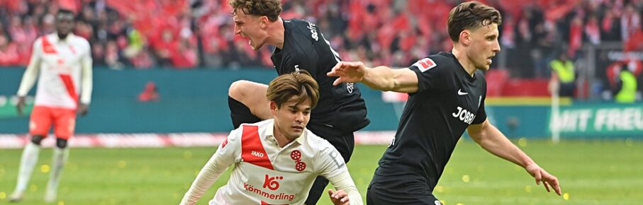 Mainz Mittelfeldspieler' Kaishu Sano im Duell mit Freiburgs Patrick Osterhage und Maximilian Eggestein