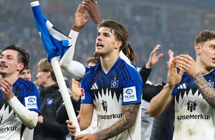 Luka Vuskovic feiert nach dem Derbysieg mit der HSV-Eckfahne als Flagge in der Hand.